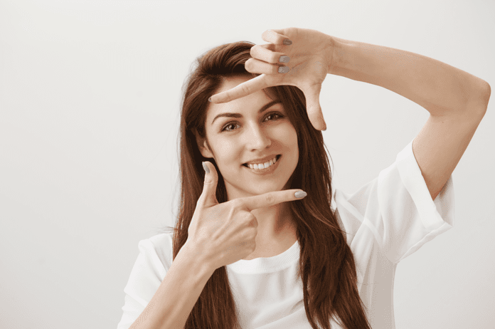 A girl framing her face for AI headshot