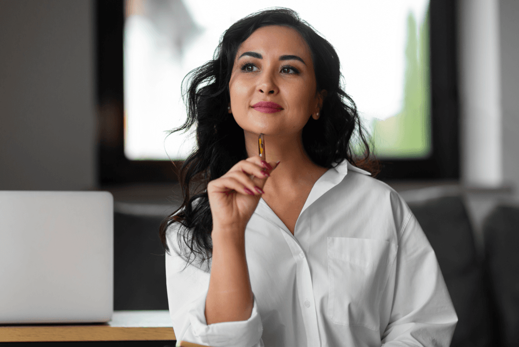 Picture shows a women founder smiling and thinking