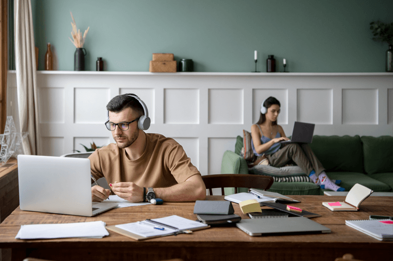 2 people working on a laptop.